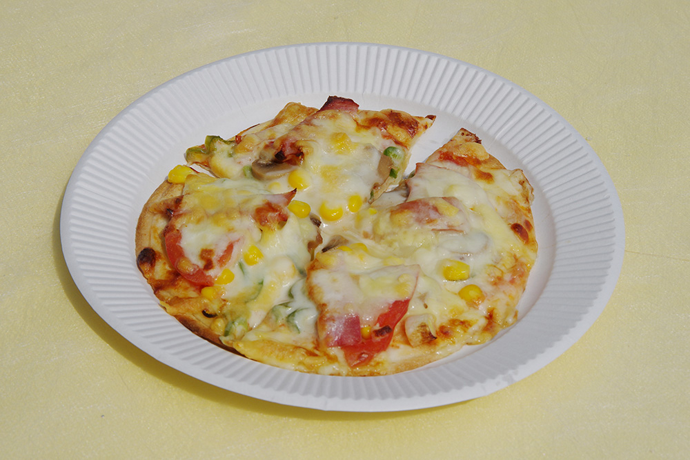 チーズとコーンがのったピザの画像