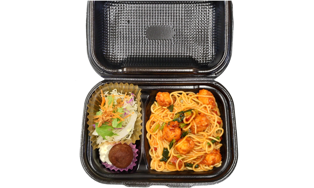 黒い容器にパスタがのっている画像
