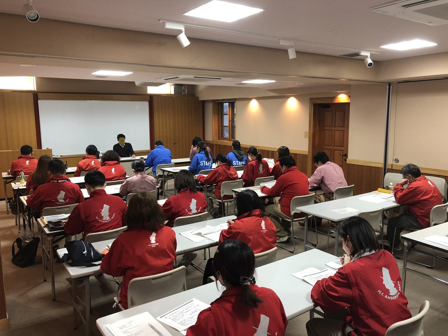 約20人ぐらいの受講生が講師の話を聞いている画像