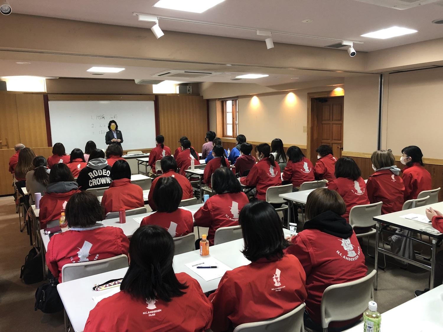 約20人ぐらいの受講生が講師の話を聞いている画像